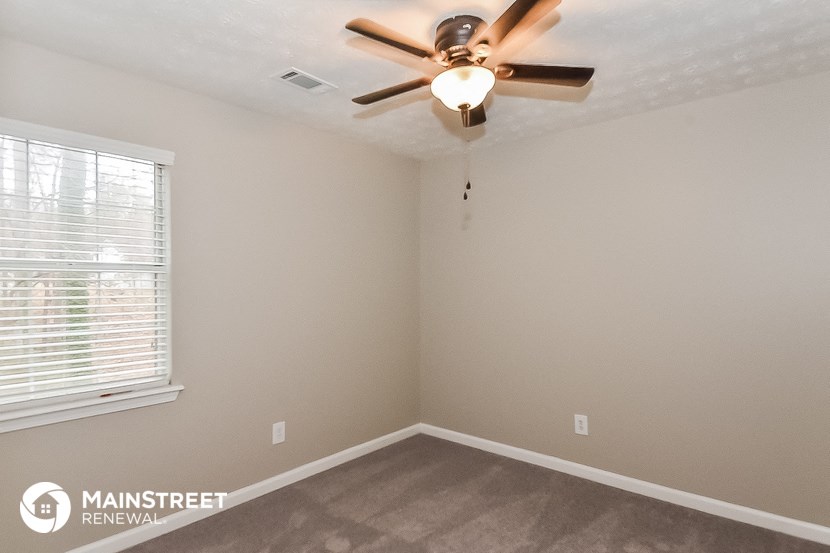 the bedroom has a ceiling fan and a window