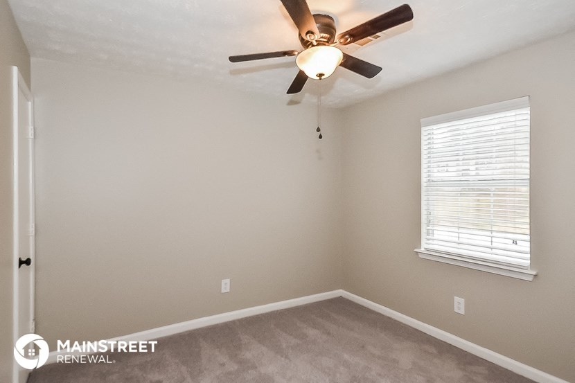 a bedroom with a ceiling fan and a window