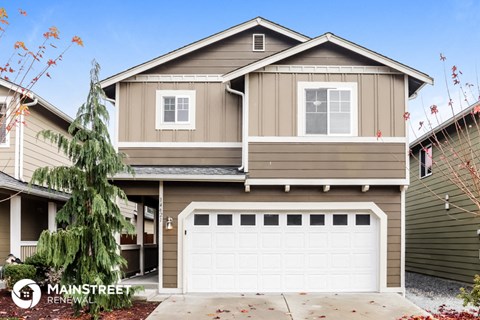 a brown house with a white garage door