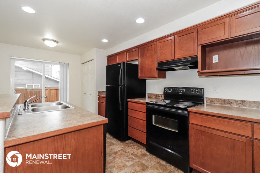 a kitchen with black appliances and wooden cabinets