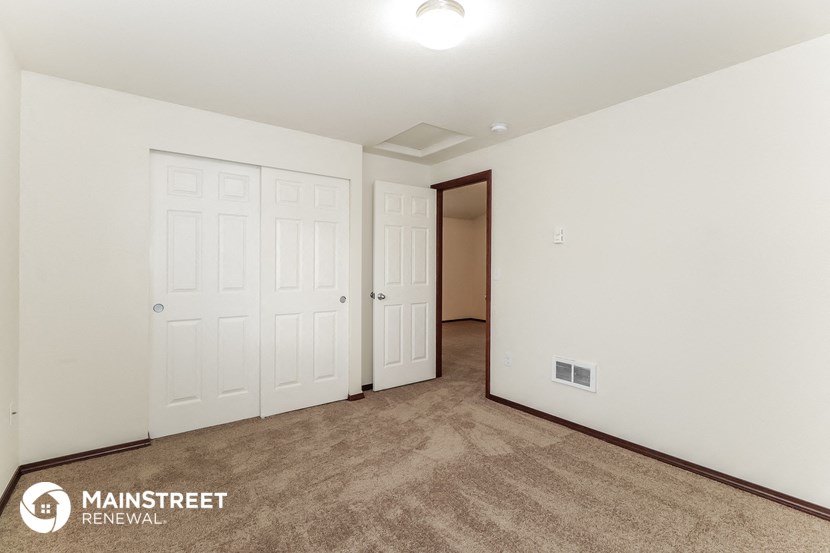a bedroom with two closets and a door to a hallway