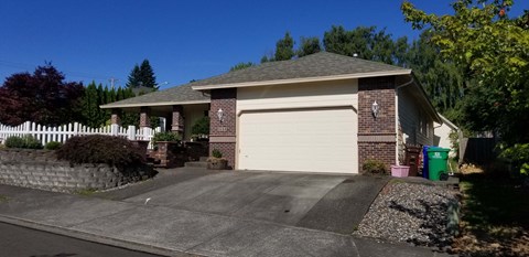 A house with a white garage door and a brick chimney.