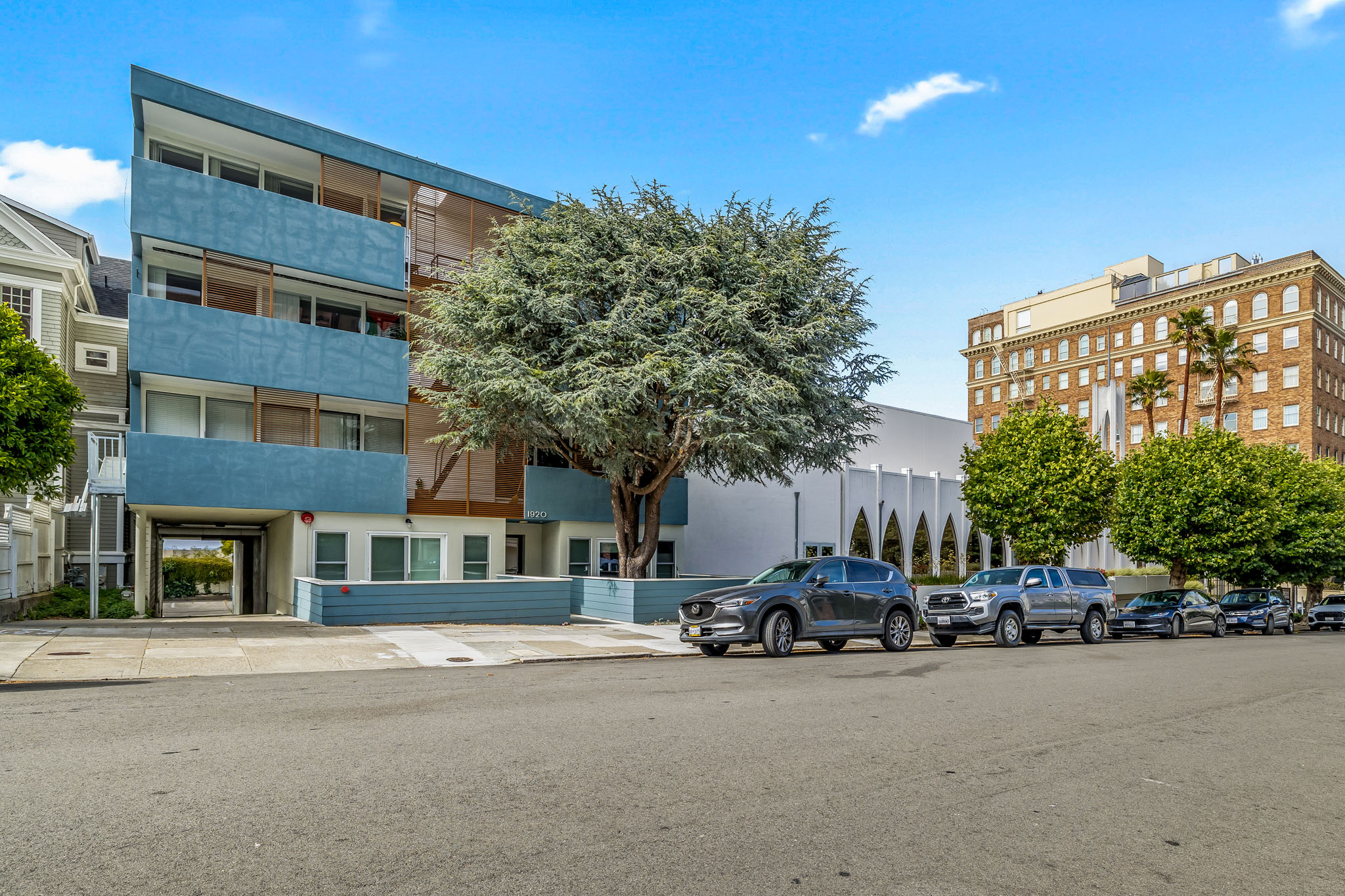 A blue and white building with a tree in front of it.
