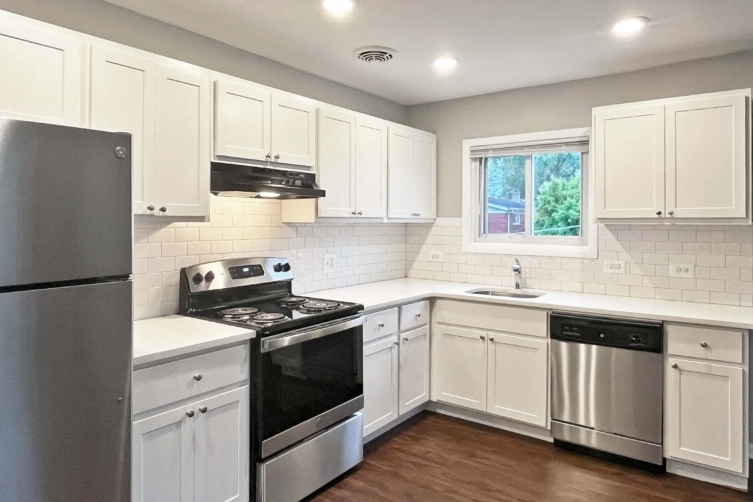 A kitchen with white cabinets and stainless steel appliances.