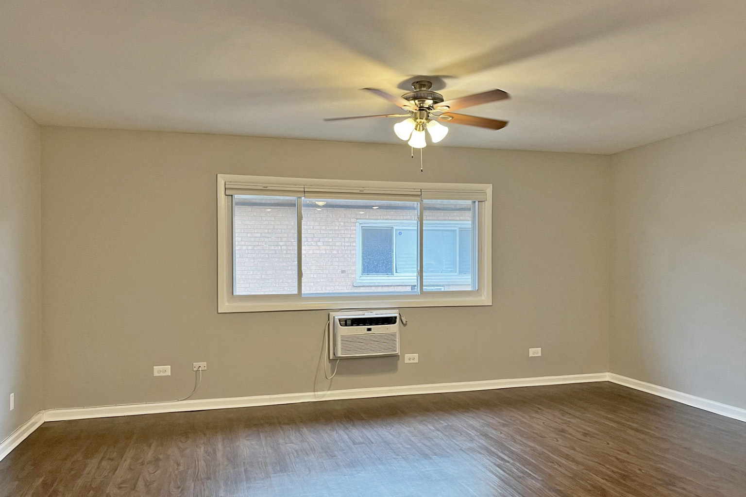 A room with a ceiling fan and a window.