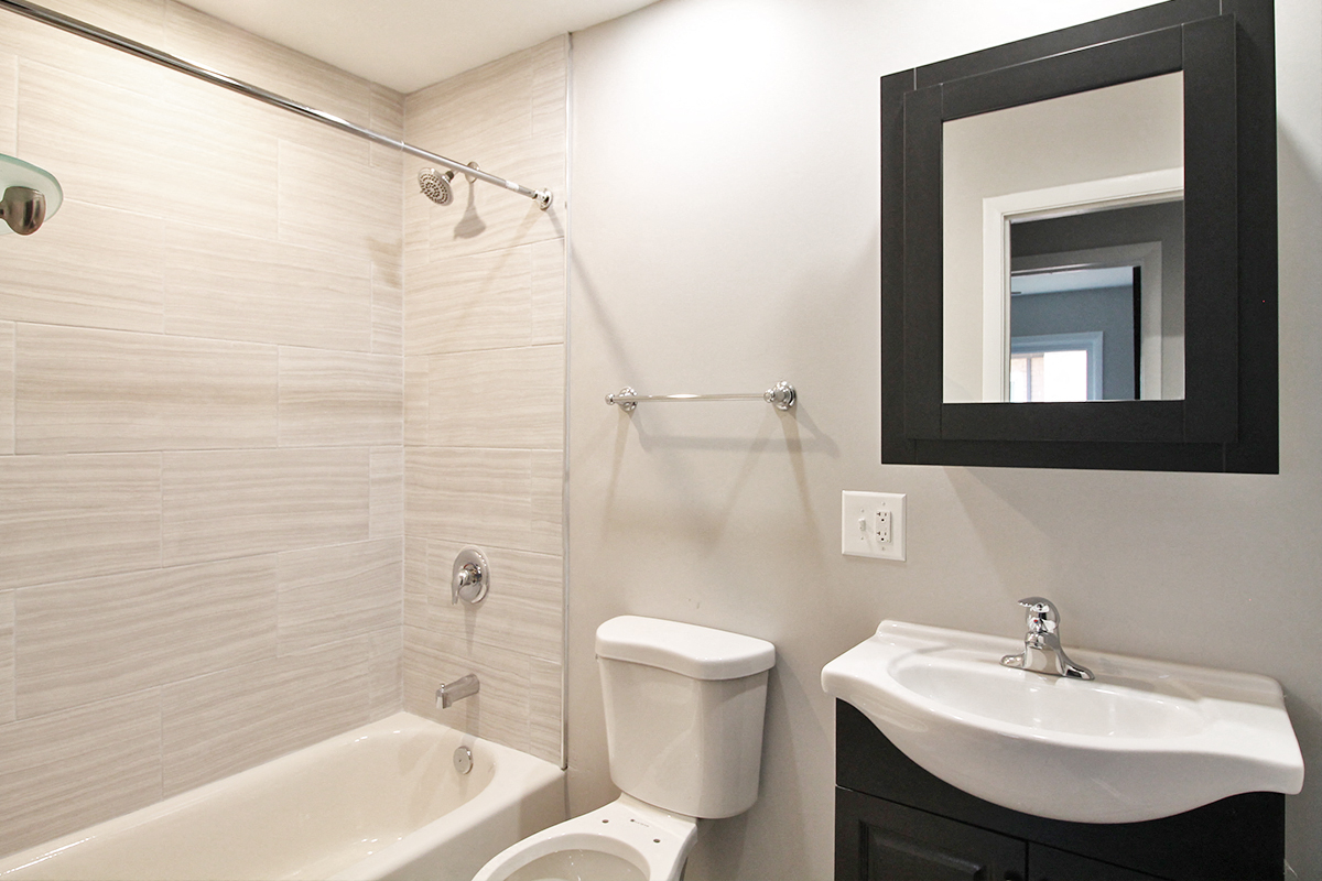 a bathroom with a sink toilet and bath tub and a mirror