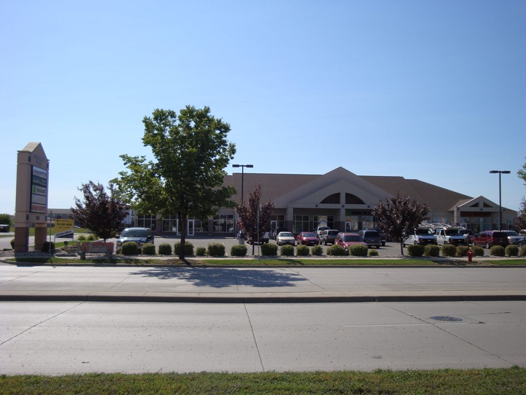 an empty parking lot in front of a shopping center with a building