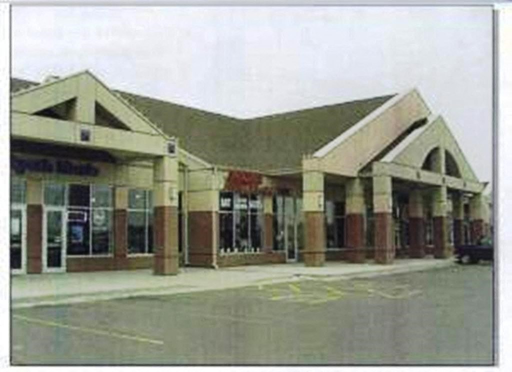 the front of a building with a parking lot