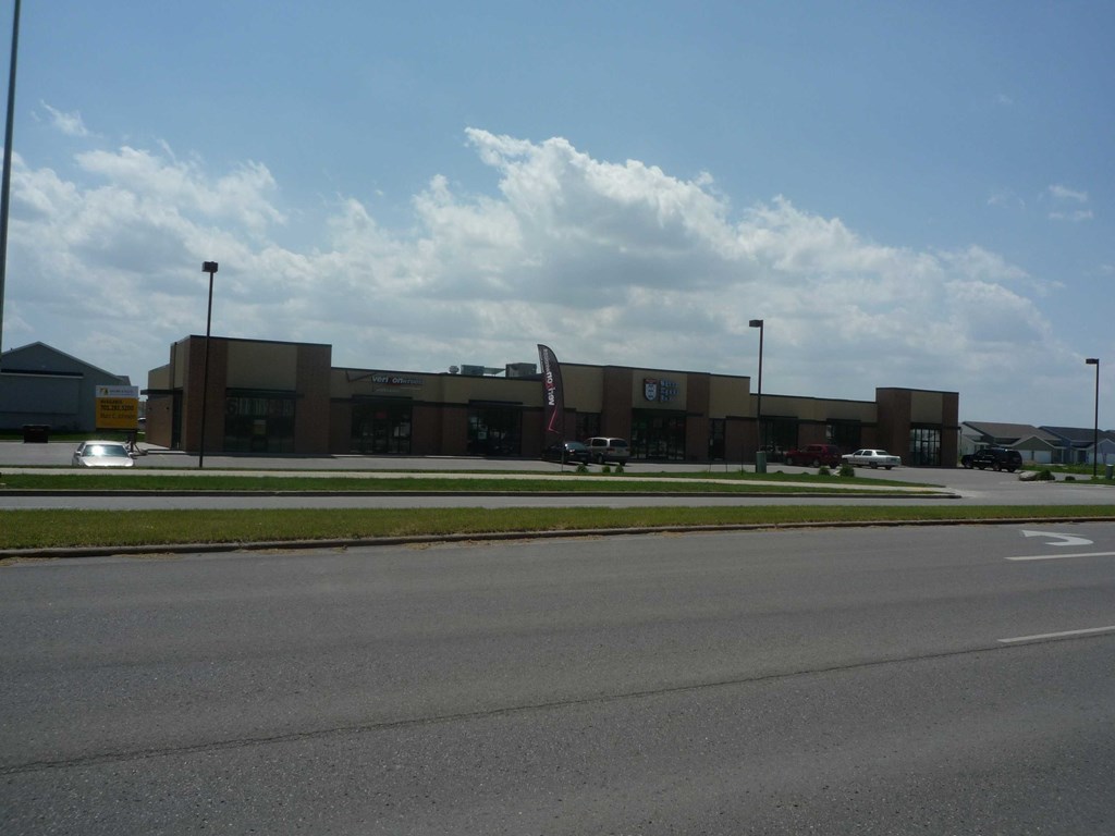 A large building with a parking lot in front.