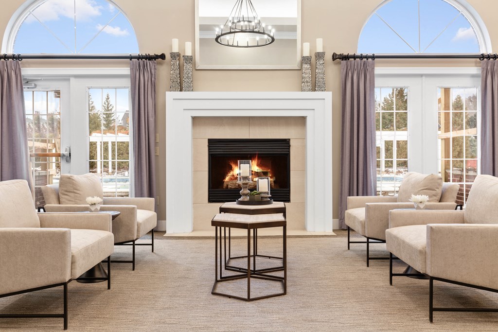 a living room with chairs and a fireplace