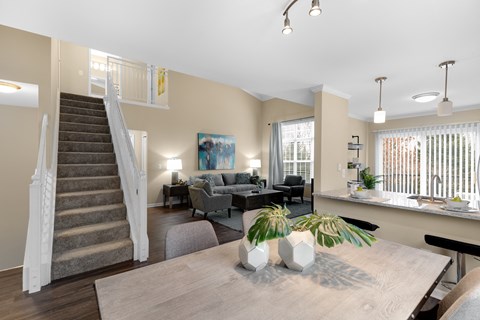a living room with a wooden table and a staircase