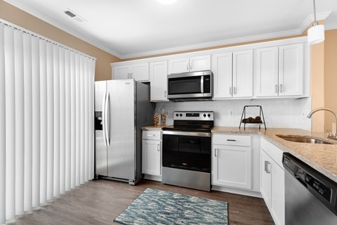 a kitchen with white cabinets and stainless steel appliances