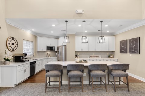 a kitchen with a large island with four chairs