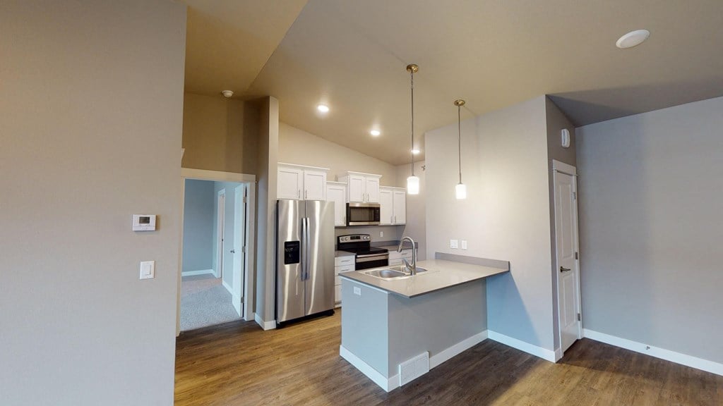 a kitchen with a large island and a stainless steel refrigerator