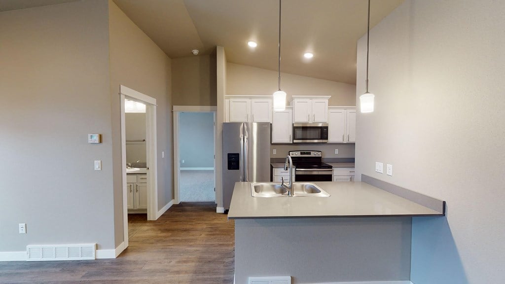 a kitchen with white cabinets and a stainless steel refrigerator