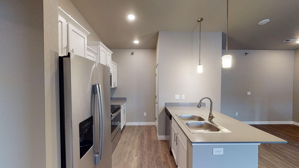 a kitchen with white cabinets and a stainless steel refrigerator