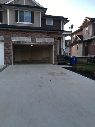 a driveway in front of a house with the garage door open