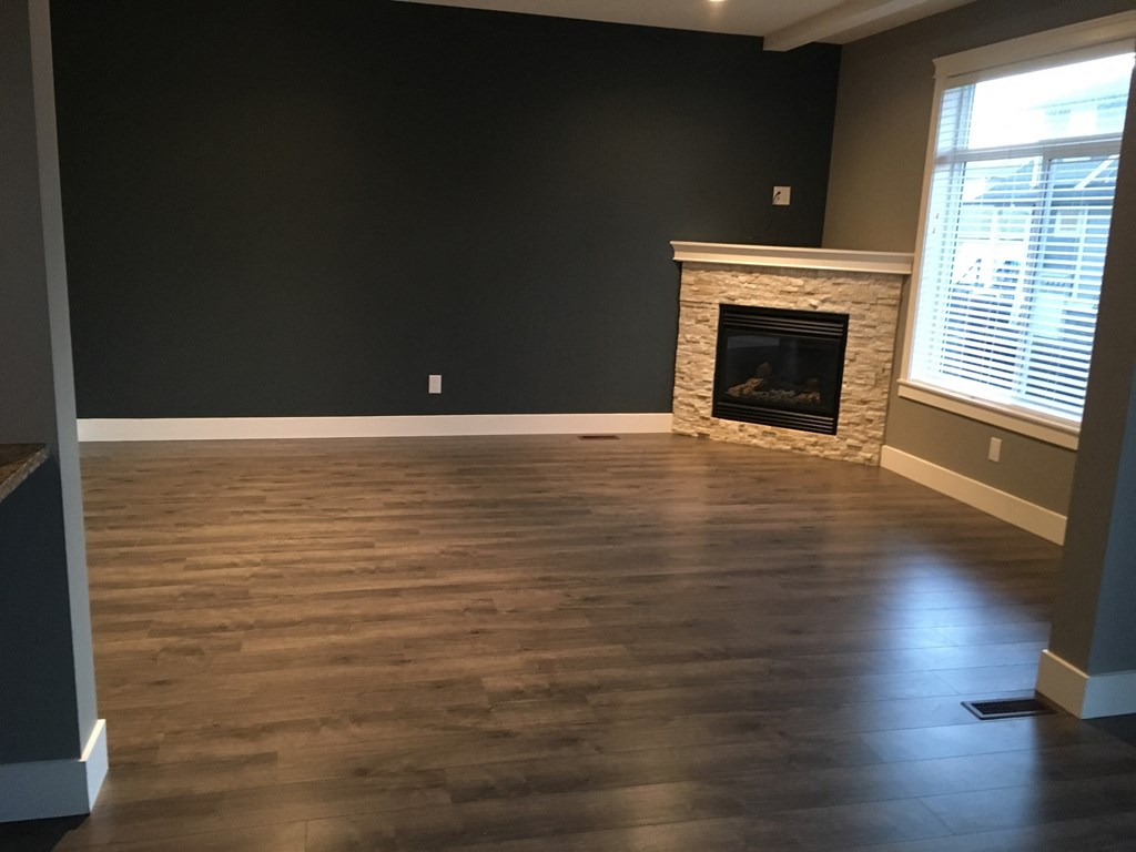 a living room with wood floors and a fireplace