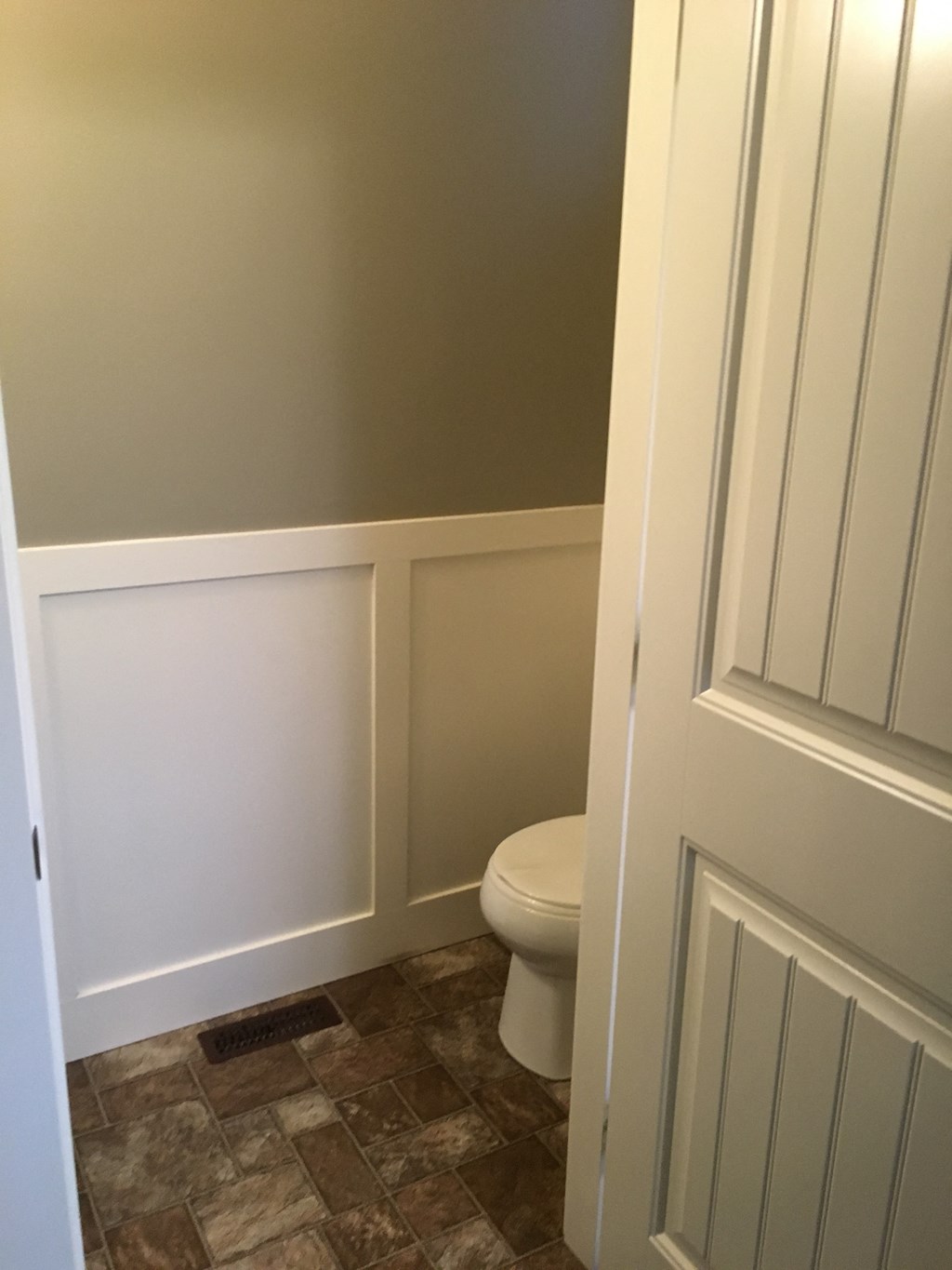a small bathroom with a toilet and white walls