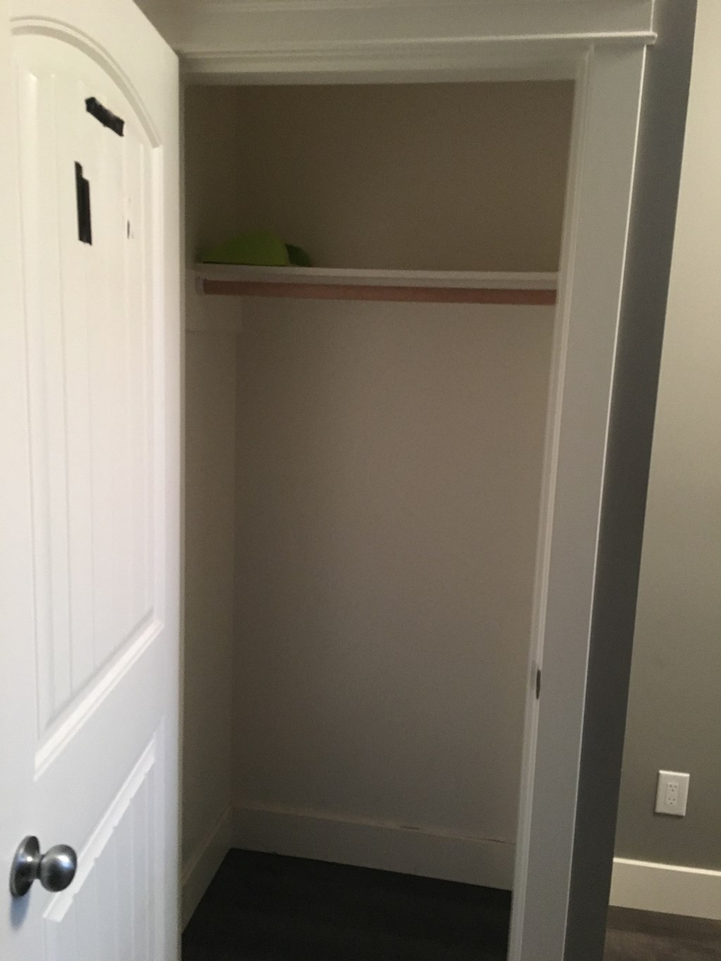 a small closet with a shelf above it and a door