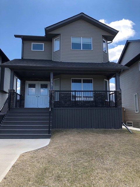 the front of a house with a porch and stairs