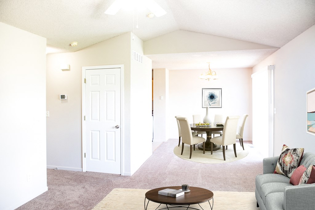 a living room and dining room with a table and chairs