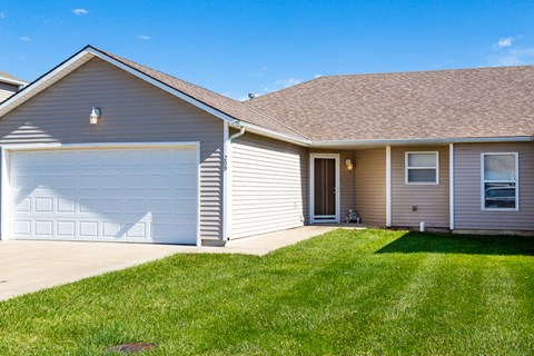 a house with a garage door and a lawn