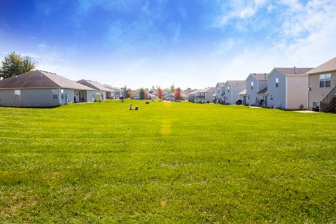 a green lawn in front of a row of houses