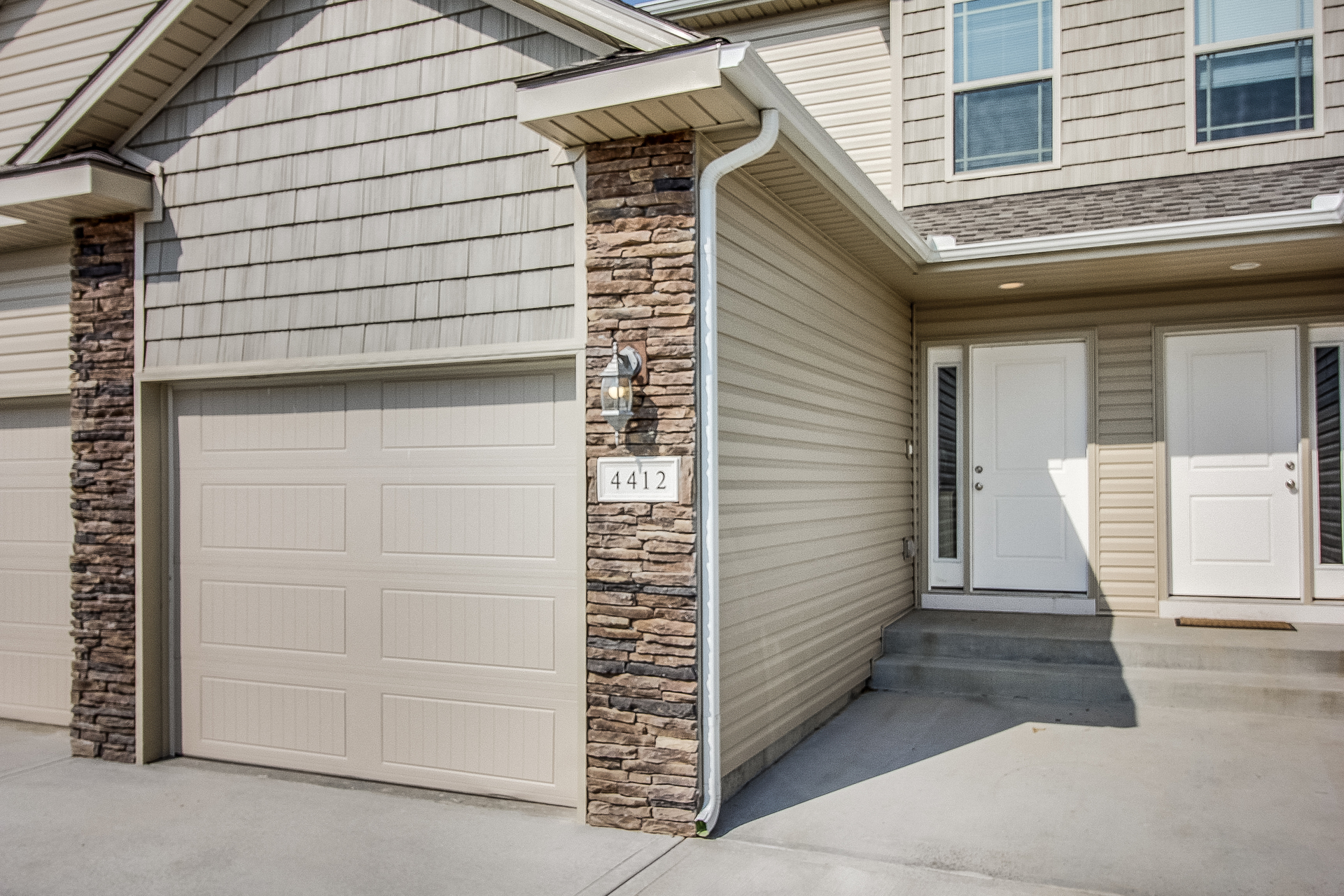 the front of a house with a white garage door