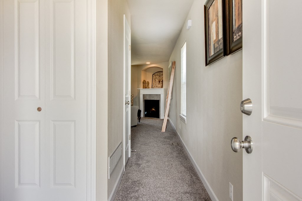 a hallway with white walls and a white door