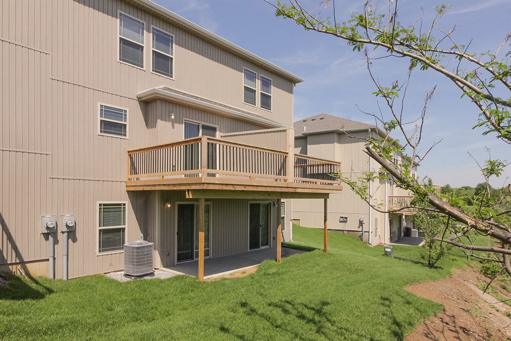 the back of a house with a deck and a yard