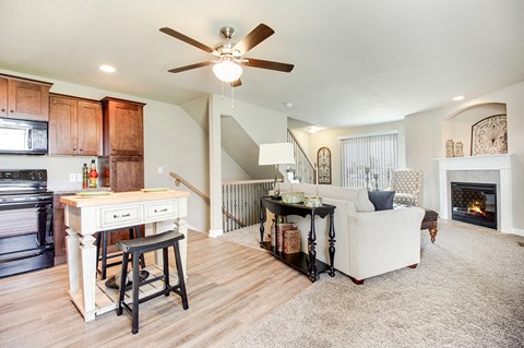 a living room with a couch and a kitchen and a ceiling fan