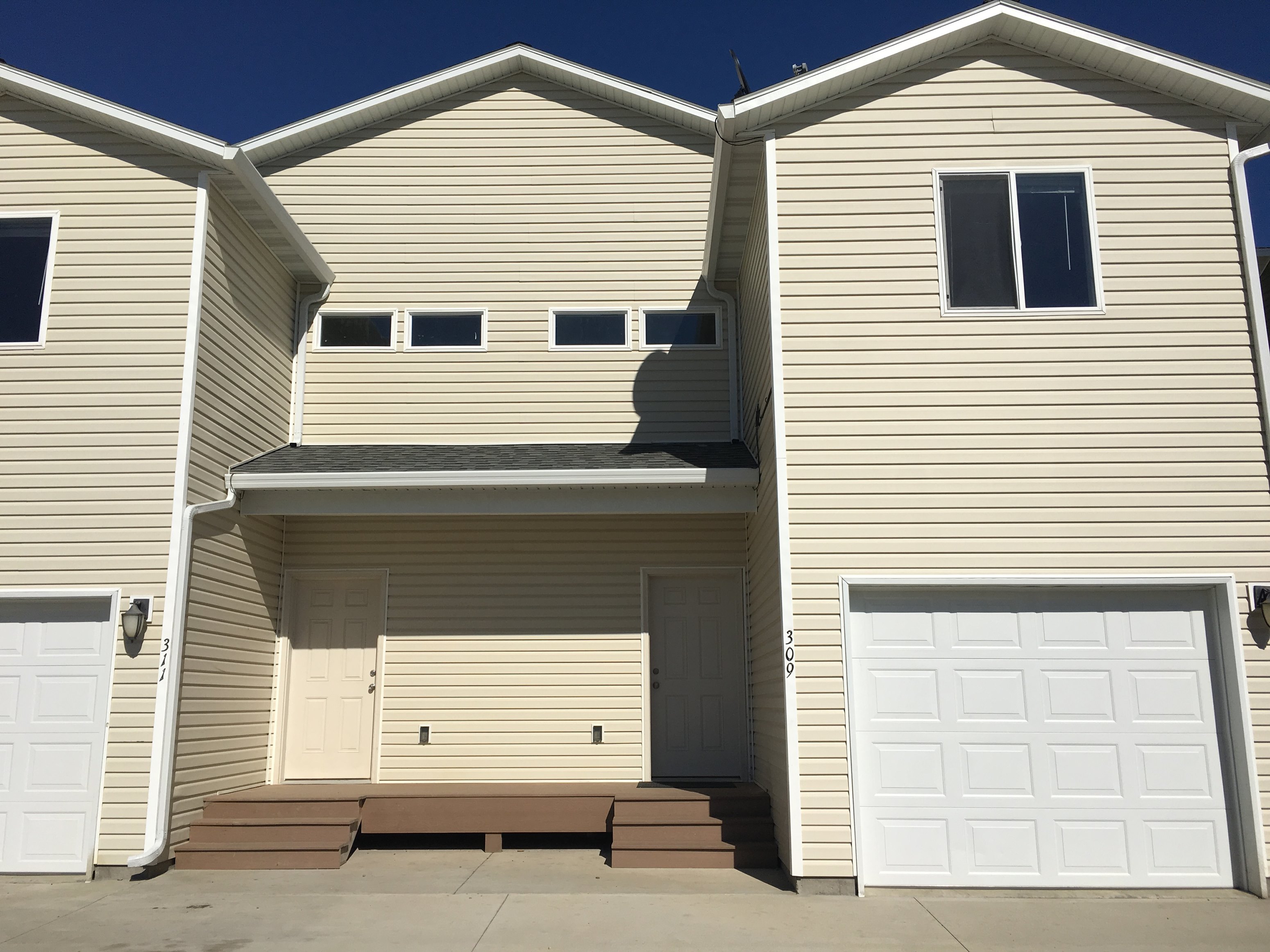 a house with two garages and a white garage door