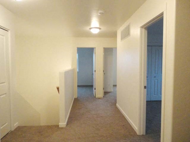 an empty hallway with a blue door and white walls