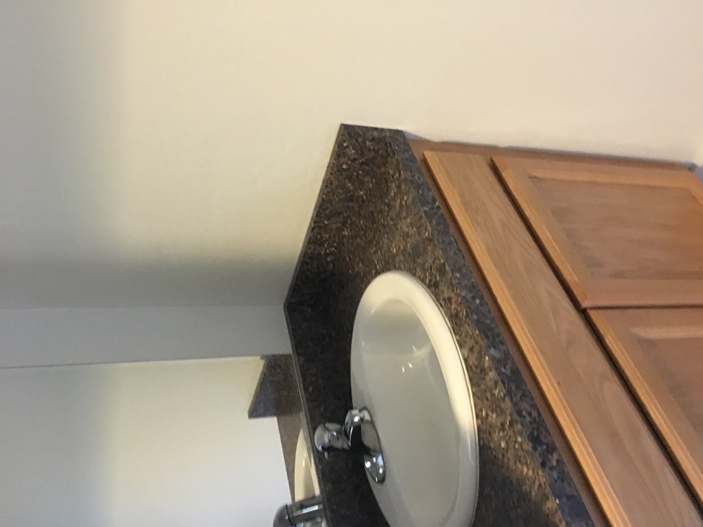 A white toilet seat is mounted on a black granite countertop.
