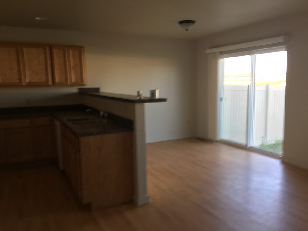 A kitchen with wooden cabinets and a black countertop.