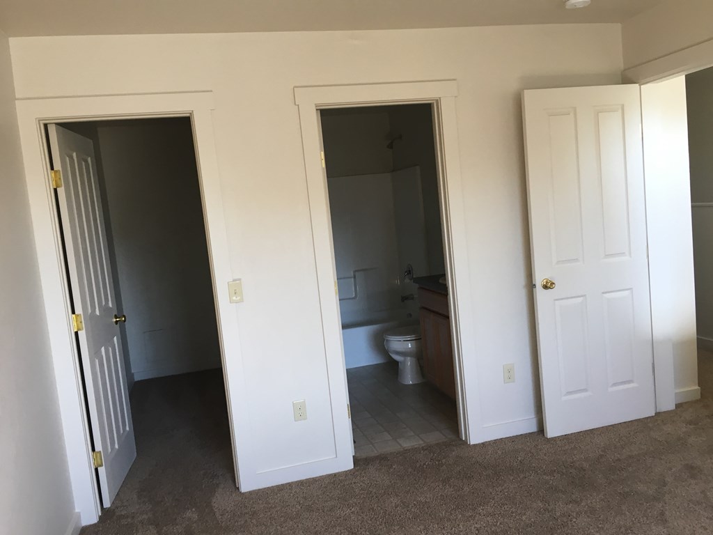 A white door is open to a bathroom.