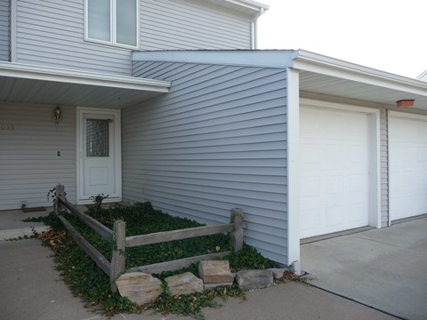 a white house with a porch and a white garage door