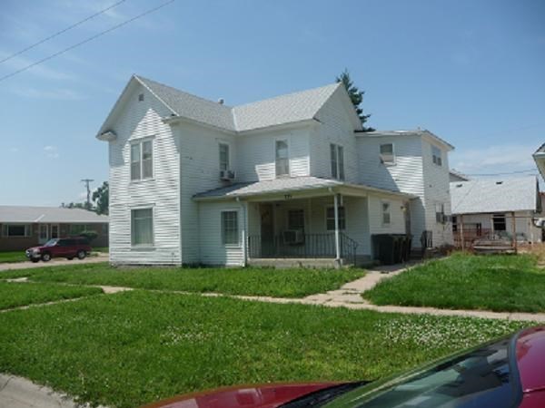 a white house with a red car parked in front of it