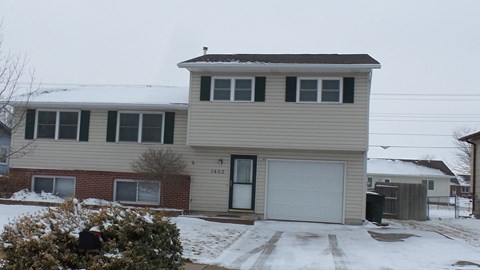 a house with snow on the roof and a white garage door