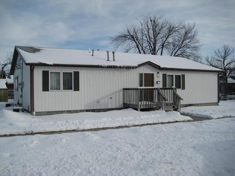 a white house with a deck in the snow