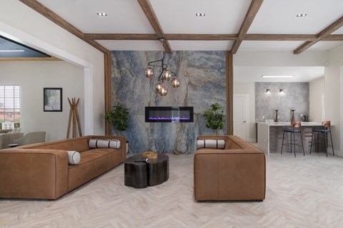 A modern living room with a large flat screen TV mounted on a stone wall.