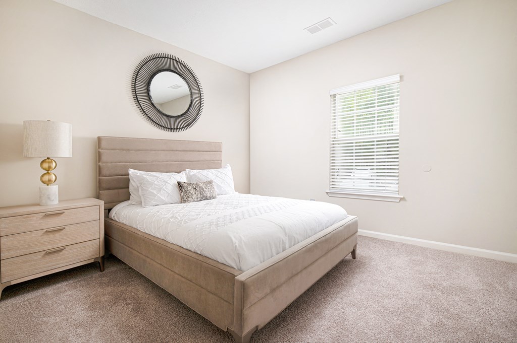 a bedroom with a bed and a dresser and a window
