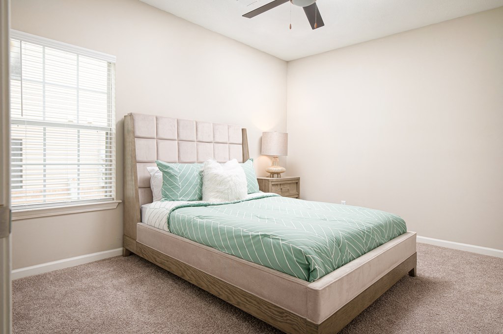 a bedroom with a bed and a ceiling fan