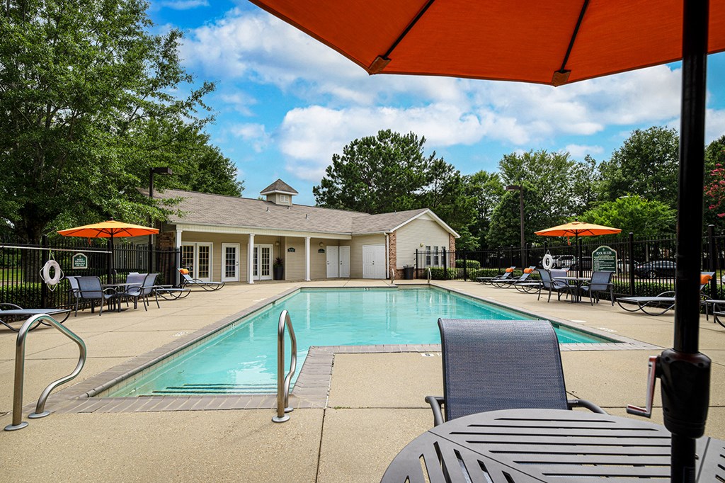 our swimming pool is in front of our clubhouse with chairs and tables