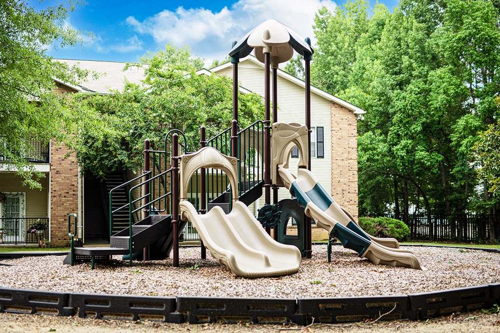 a playground with slides in front of a house
