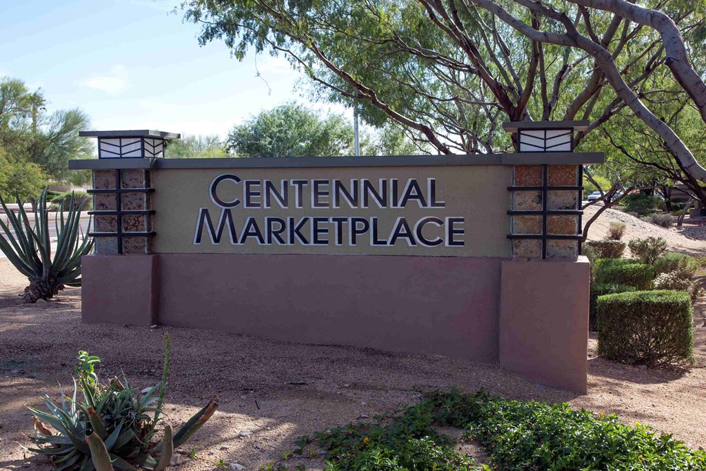 a sign for the central marketplace in front of a tree