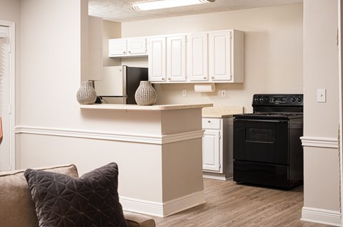 A kitchen with white cabinets and a black oven.