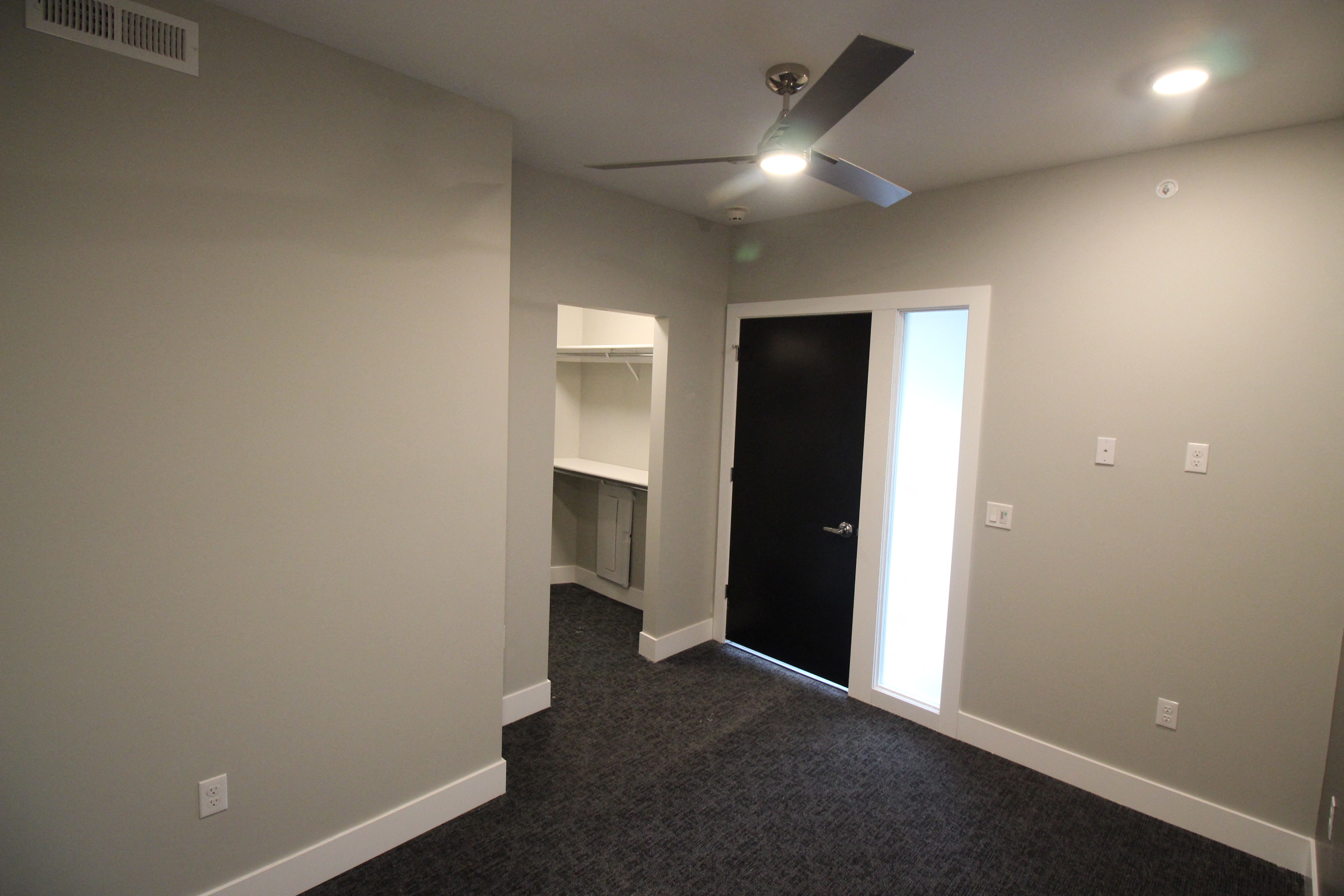 a room with a closet and a ceiling fan