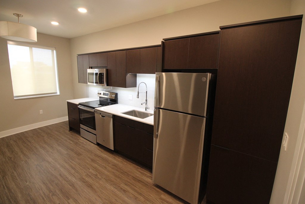 a kitchen with stainless steel appliances and dark wood cabinets